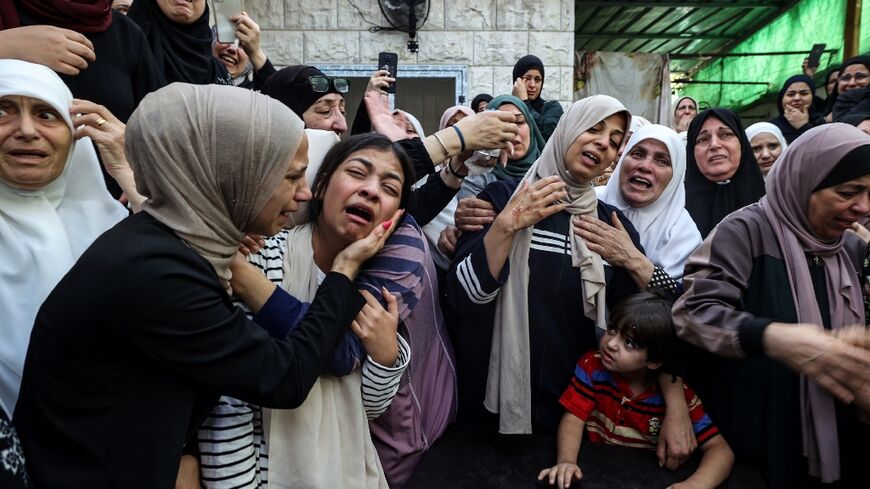 Women cry at the funeral of 18-year-old Palestinian Mahmoud Abu Saan who was shot and killed by Israeli forces in the occupied West Bank 