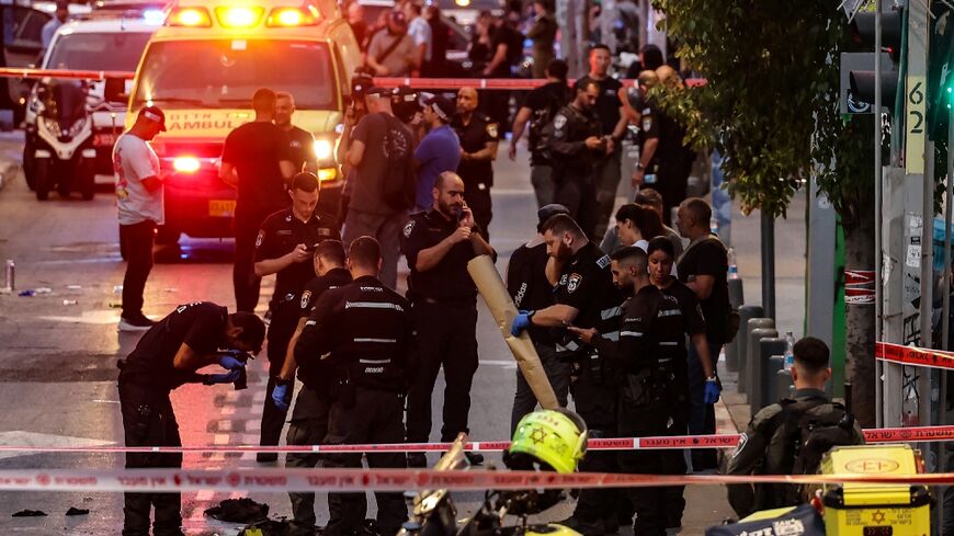 Israeli police gather evidence from the scene of a shooting in commercial hub Tel Aviv which criticially wounded an Israeli