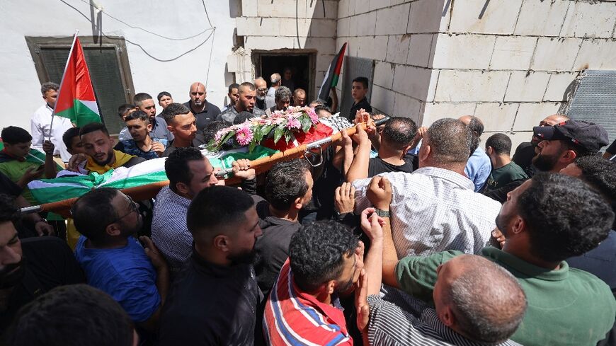 Mourners carry the body of Qusai Jamal Maatan, 19, during his funeral in the occupied West Bank village of Burqa