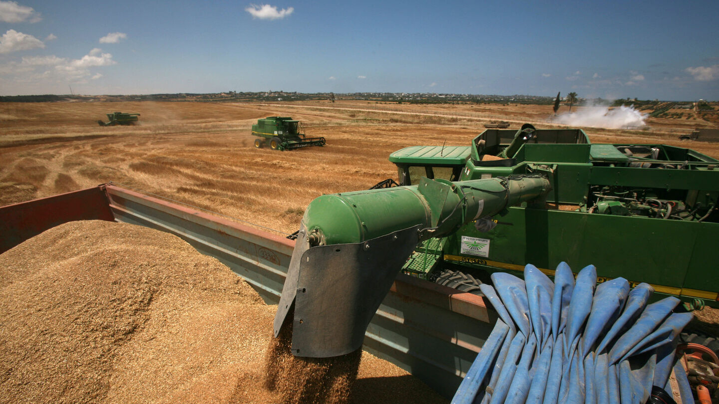 An Israeli army tank deployed on the border with the Gaza Strip creates a wall of smoke (R) to protect Israeli farmers harvesting their wheat crop on April 30, 2008 in the fields near Kibbutz Beeri in southern Israel. Getty