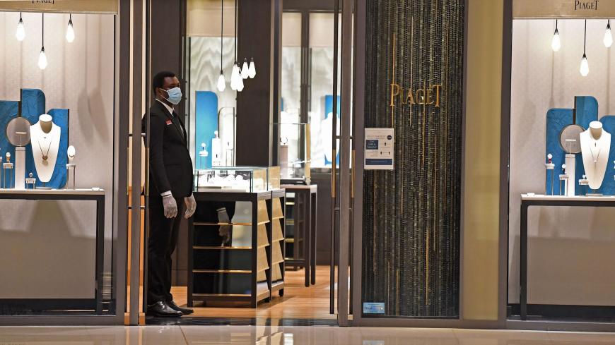 A security guard, wearing protective masks to combat the spread coronavirus, stands guard outside a store in the Mall of Dubai on April 28, 2020, after the mall was reopened. (Photo by Karim SAHIB / AFP) (Photo by KARIM SAHIB/AFP via Getty Images)