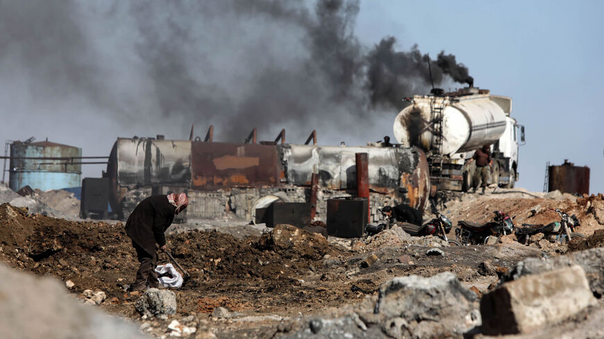 A displaced Syrian man works at a makeshift oil refinery near the village of Tarhin in an area under the control of Turkish-backed factions in the northern countryside of Aleppo, Syria, Feb. 25, 2021.