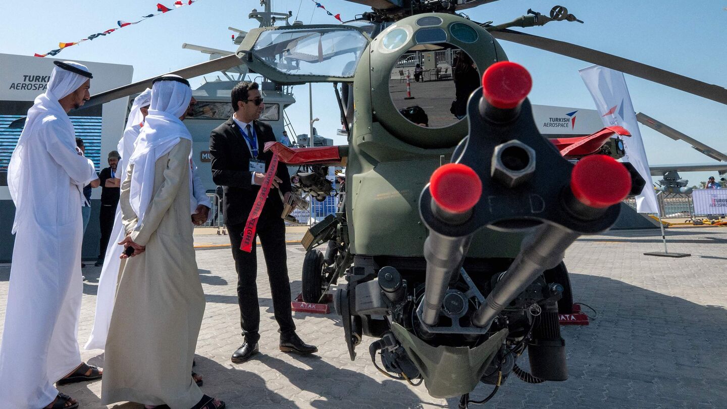 Visitors view a TAI/AgustaWestland T129 ATAK attack helicopter on display at the Turkish Aerospace stand during the Naval Defence and Maritime Security Exhibition (NAVDEX), part of the wider International Defence Exhibtion (IDEX) at the Abu Dhabi International Exhibition Centre on February 20, 2023. (Photo by Ryan LIM / AFP) (Photo by RYAN LIM/AFP via Getty Images)