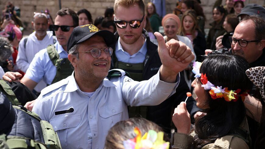 sraeli Minister of National Security Itamar Ben-Gvir (C) greets Israeli settlers dressed in Purim costumes as he walks in al-Shuhada street, largely closed to Palestinians, in the city centre of the flashpoint city of Hebron in the occupied West Bank on March 7, 2023. (Photo by HAZEM BADER / AFP) (Photo by HAZEM BADER/AFP via Getty Images)