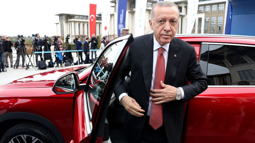 Turkey's President Recep Tayyip Erdogan stands next to his Togg T10X, Turkey's first domestically-produced electric car, after receiving it from the company at the Presidential Complex in Ankara, on April 3, 2023. (Photo by Adem ALTAN / AFP) (Photo by ADEM ALTAN/AFP via Getty Images)