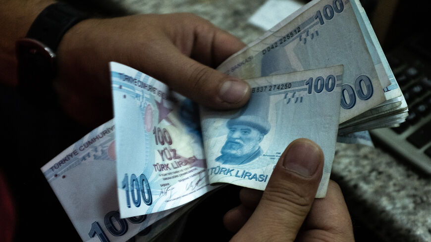 A man counts Turkish liras at a currency exchange office, Istanbul, Turkey, July 29, 2020.