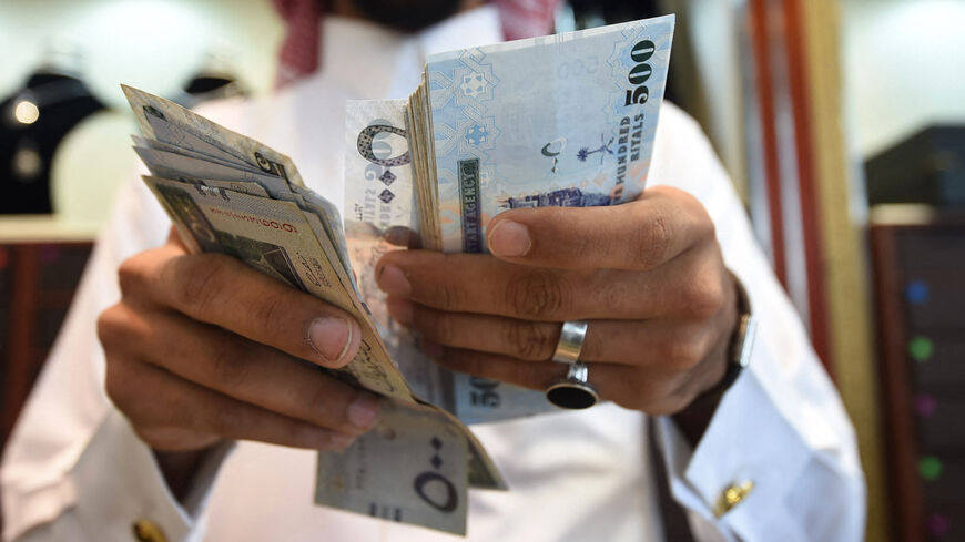 A man counts Saudi riyal banknotes at his jewelry shop in Tiba market in the capital Riyadh on Oct. 3, 2016.