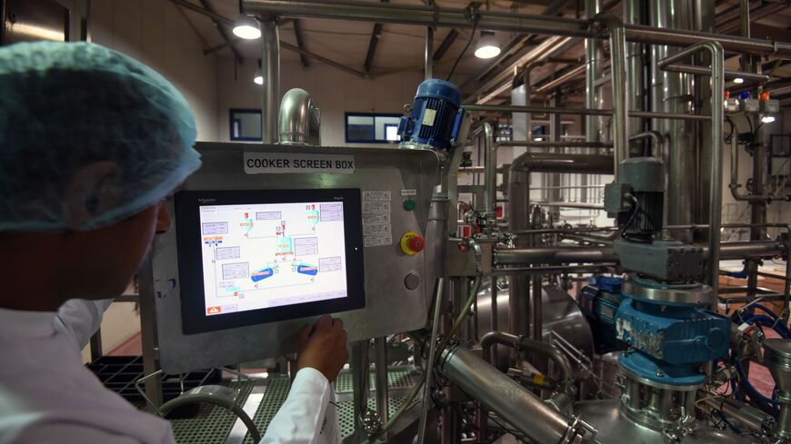 A worker operates a production line panel in a production hall at the Agrana food factory in the Egyptian capital Cairo on October 11, 2016. Agrana is an Austrian multinational company which processes agricultural commodities into industrial products, with a joint-venture in fruit preparation in Egypt. / AFP / MOHAMED EL-SHAHED (Photo credit should read MOHAMED EL-SHAHED/AFP via Getty Images)