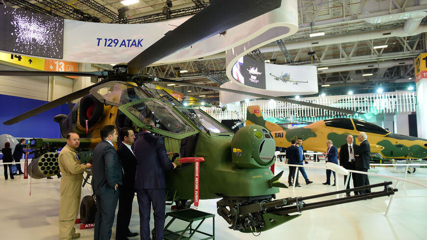 People look at a Turkish attack helicopter "T129 ATAK" on May 9, 2017 during the opening day of the 13th International Defense Industry Fair (IDEF) in Istanbul. / AFP PHOTO / YASIN AKGUL (Photo credit should read YASIN AKGUL/AFP via Getty Images)