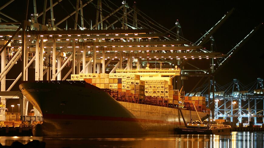 Cranes move shipping containers on a Maersk Sealand ship.