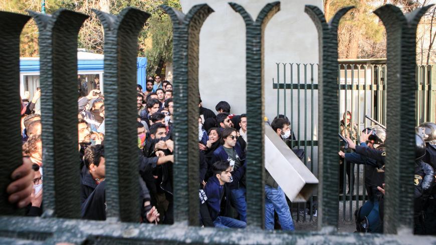 Iranian students scuffle with police at the University of Tehran during a demonstration driven by anger over economic problems, in the capital Tehran on December 30, 2017. 
Students protested in a third day of demonstrations, videos on social media showed, but were outnumbered by counter-demonstrators.  / AFP PHOTO / STR        (Photo credit should read STR/AFP/Getty Images)