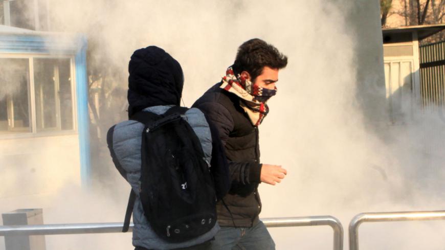 Iranian students run for cover from tear gas at the University of Tehran during a demonstration driven by anger over economic problems, in the capital Tehran on December 30, 2017. 
Students protested in a third day of demonstrations, videos on social media showed, but were outnumbered by counter-demonstrators.  / AFP PHOTO / STR        (Photo credit should read STR/AFP/Getty Images)