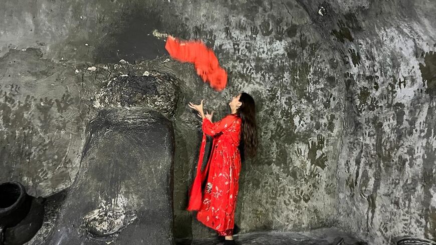 A Yazidi girl catches a scarf in a religious ritual at the Lalish temple in Dahuk, Nov. 17, 2022.