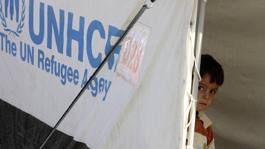 A displaced boy, who fled from Salahuddin province stands in a tent at a refugee camp, on the outskirts of Kirkuk, December 17, 2014. REUTERS/Ako Rasheed (IRAQ - Tags - Tags: POLITICS CIVIL UNREST SOCIETY POVERTY) - RTR4IESO