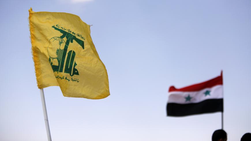 Hezbollah and Syrian flags are seen fluttering in Fleita, Syria August 2, 2017. REUTERS/ Omar Sanadiki - RC15E3E7FA20