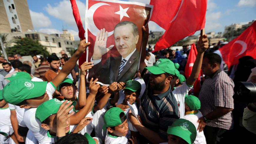 Palestinians hold a poster of Turkish President Tayyip Erdogan during a Hamas rally in support of Erdogan's government against a coup attempt, in Khan Younis in the southern Gaza Strip July 16, 2016. REUTERS/Ibraheem Abu Mustafa     TPX IMAGES OF THE DAY      - S1AETPWJGAAA