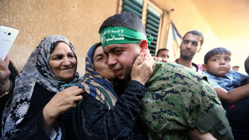 Freed Palestinian prisoner Mohammed al-Bashiti, who served 12 years in an Israeli jail after he was convicted of being a member of Hamas' armed wing, is kissed by his aunt upon his release, in Rafah in the southern Gaza Strip, July 25, 2016. REUTERS/Ibraheem Abu Mustafa  - S1BETRQHDIAA