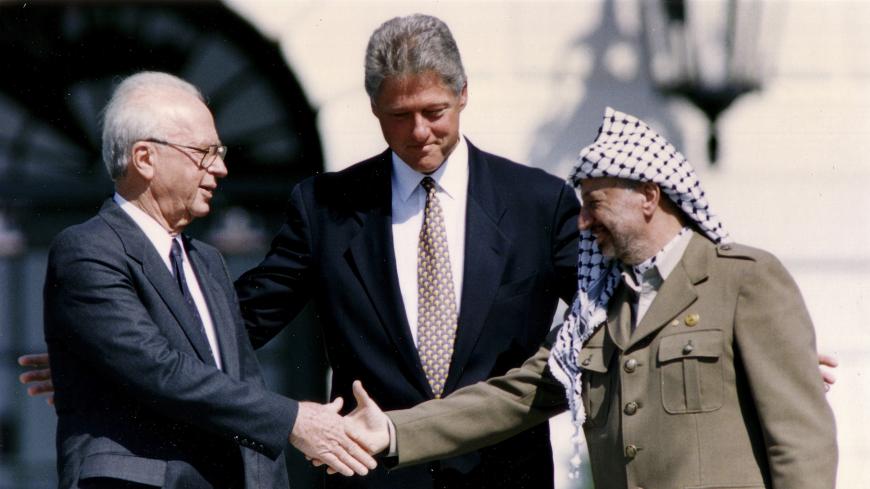 PLO Chairman Yasser Arafat (R) shakes hands with Israeli Prime Minister Yitzhak Rabin (L), as U.S. President Bill Clinton stands between them, after the signing of the Israeli-PLO peace accord, at the White House in Washington September 13, 1993. REUTERS/Gary Hershorn (UNITED STATES - Tags: POLITICS) - GM1E99D1UCD01