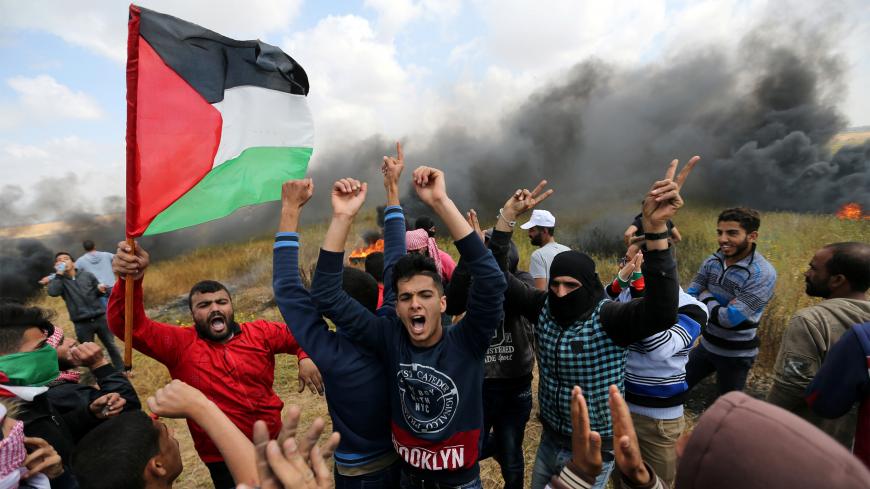 Palestinians shout during clashes with Israeli troops, during a tent city protest along the Israel border with Gaza, demanding the right to return to their homeland, the southern Gaza Strip March 30, 2018. REUTERS/Ibraheem Abu Mustafa - RC1AF1973D70