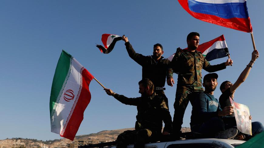 Syrians wave Iranian, Russian and Syrian flags during a protest against U.S.-led air strikes in Damascus,Syria April 14,2018.REUTERS/ Omar Sanadiki     TPX IMAGES OF THE DAY - RC1815671B90