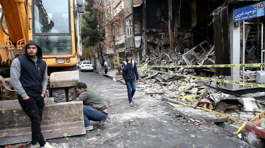 People walk near a burnt bank, after protests against increased fuel prices, in Tehran, Iran November 20, 2019. Picture taken November 20, 2019. Nazanin Tabatabaee/WANA (West Asia News Agency) via REUTERS ATTENTION EDITORS - THIS IMAGE HAS BEEN SUPPLIED BY A THIRD PARTY - RC2GGD9E7BEK